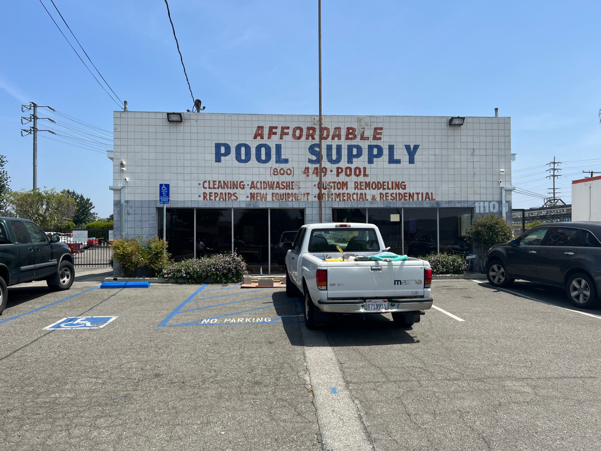 Affordable Pool Supply storefront before the sign upgrade, with faded hand-painted lettering on white tile
