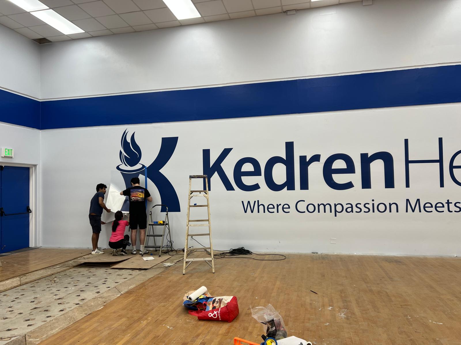 Kedren Health wall graphics being installed inside a community health facility