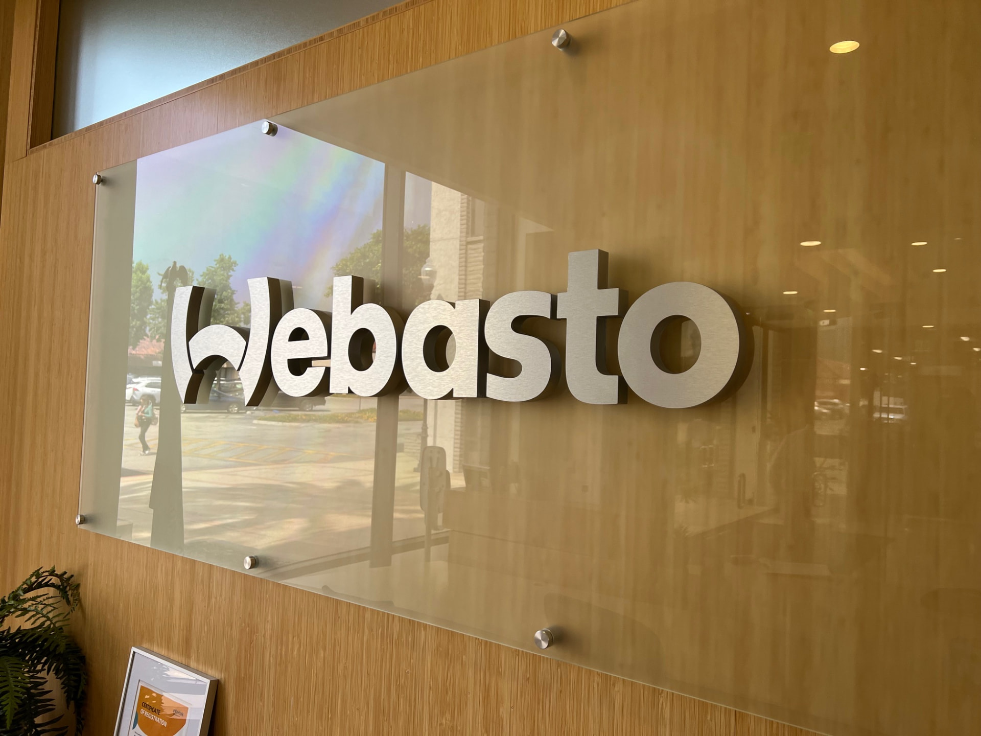 Brushed metal Webasto lobby sign mounted on a glass panel
