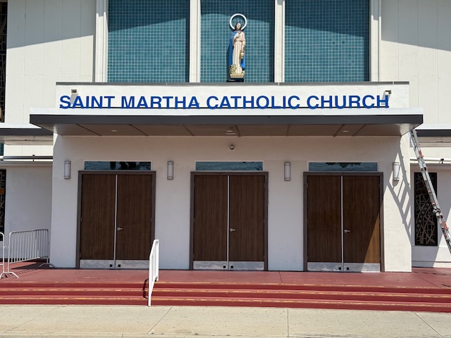 Saint Martha Catholic Church entry canopy with blue dimensional letters above three wooden doors
